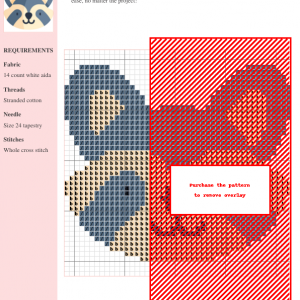 Cross stitch pattern featuring a charming raccoon face, primarily in shades of blue and beige.