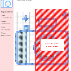 Image of a cross stitch pattern depicting a cute, light blue camera with a pink heart in the lens.